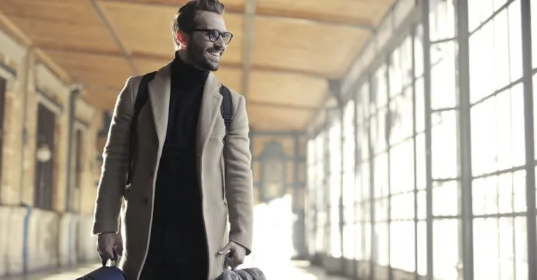 Man In Brown Robe Carrying Bag Smiling