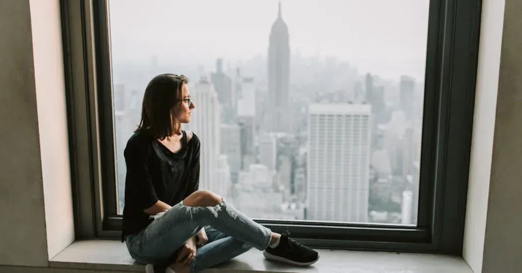 Woman In Black Jacket And Blue Denim Jeans Sitting On Window With The View On Empire State Building