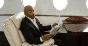Partnerships Articles &Amp; News 7 April 16, 2026 An Adult Man In A Black Suit Reads A Newspaper While Sitting In A Private Jet'S Luxurious Interior.