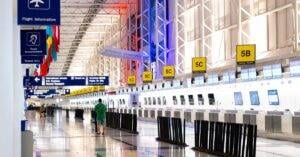 Wide View Of Chicago Airport Terminal Showcasing Architecture And Check-In Counters. Flags And Signages Add Vibrant Detail.
