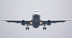 A Commercial Airliner Captured Head-On, Preparing To Land Against A Cloudy Sky.