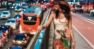 Partnerships Articles &Amp; News 2 April 16, 2026 A Joyful Woman Standing By City Traffic, Embodying Vibrant Urban Life At Night.