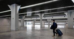Luxury Car &Amp; Limo Services Articles &Amp; News 7 June 1, 2026 A Man With Luggage Walking Through A Spacious, Modern, Empty Airport Hall.