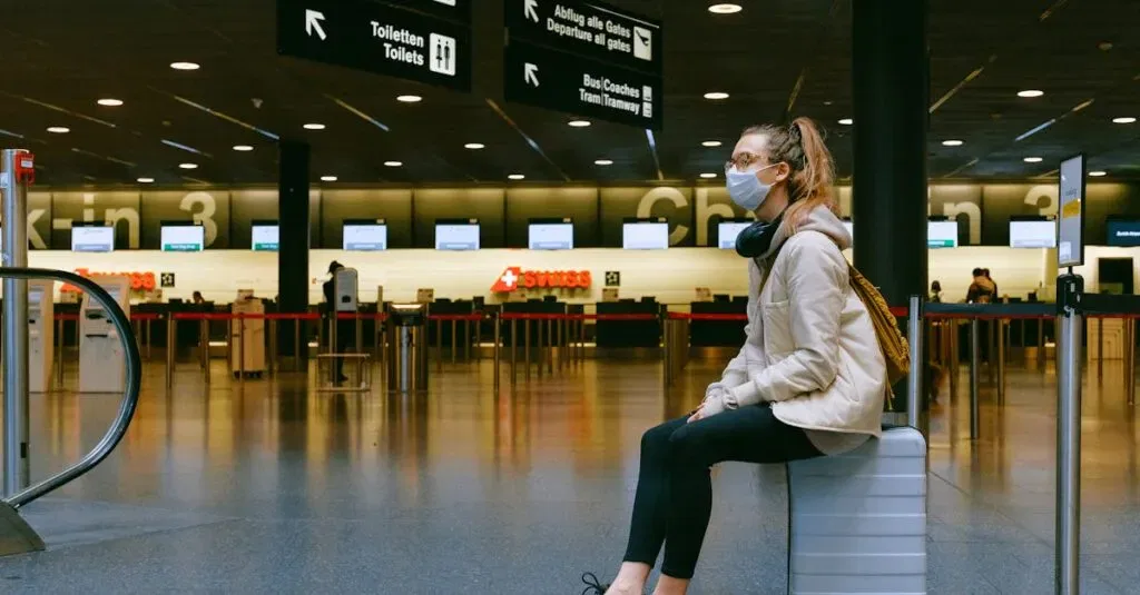 A Woman Wearing A Face Mask Sits On Luggage In An Airport Terminal Amid The Pandemic.