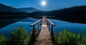 Discover Tranquility At A Moonlit Dock In Whistler, Bc, Under A Starry Sky.