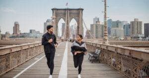 A Couple Jogging And Enjoying Fitness On The Iconic Brooklyn Bridge In New York City.