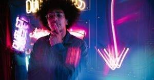 Colorful Image Of A Stylish Young Adult Surrounded By Vibrant Neon Signs.