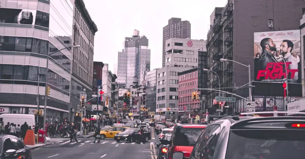 Lively City Street In New York With Bustling Traffic And Urban Buildings During The Day.