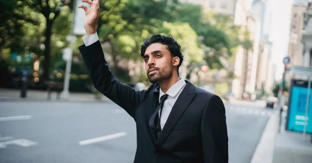 A Man In A Suit Raises His Hand To Hail A Taxi On A City Street.