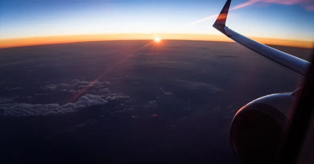 Stunning Aerial View From An Airplane Window Showing The Wing And A Sunset Over The Clouds.