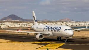Finnair Aircraft On Runway With Lanzarote'S Volcanic Landscape In Background.