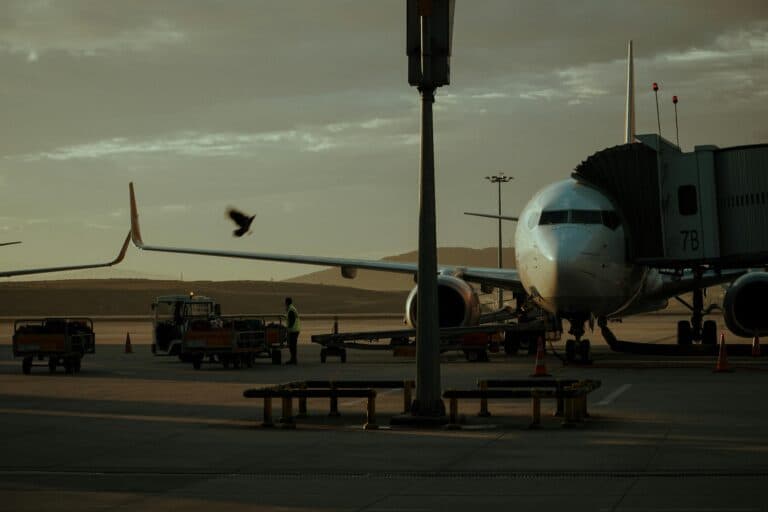 New York Blogs | Articles | News | Tips &Amp; Tricks | Video | Faq | Information | Infograph. 6 June 11, 2026 A Parked Airplane At An Airport Gate With A Boarding Bridge And Vehicles Visible At Twilight.