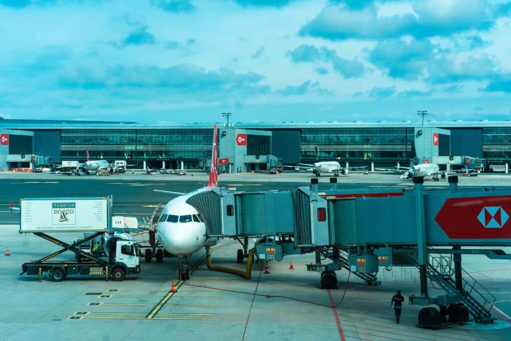 Car Service Jfk Airport In 2026: The One That Actually Shows Up When Your Plane Lands Late 10 June 10, 2026 Airplane At Gate With Jetway And Loading Trucks At A Bustling Airport.