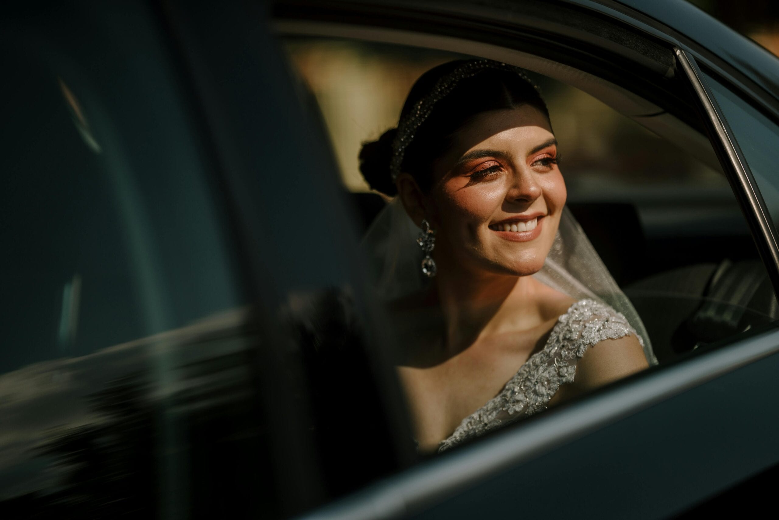 Radiant Bride Smiling From Limousine Window, Capturing A Joyful Wedding Moment.