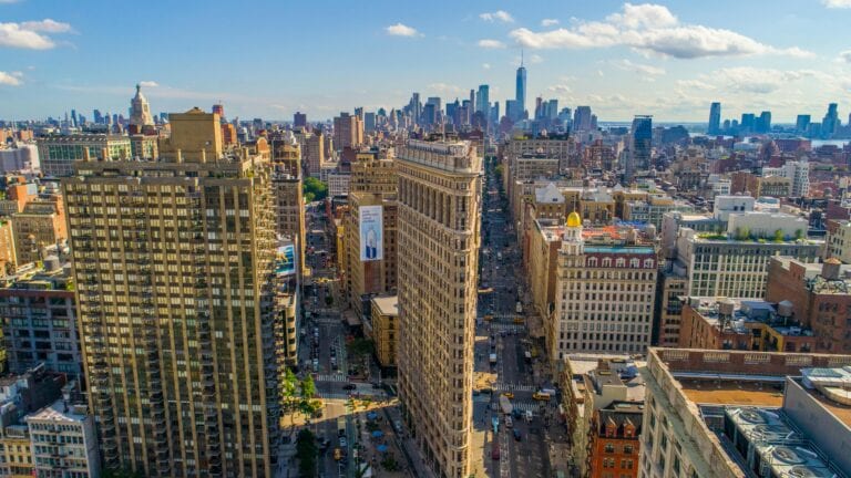 Stunning Aerial View Of New York City'S Skyline Featuring The Iconic Flatiron Building On A Sunny Day.