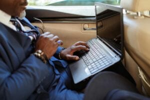 Corporate Travel Articles &Amp; News 3 May 20, 2026 Close-Up Of A Businessman Typing On A Laptop In A Car Interior During Travel.