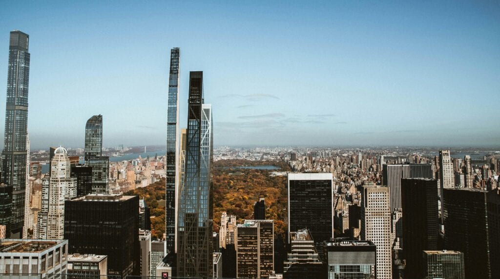 High-Rise View Overlooking Central Park And New York Skyscrapers Under A Clear Blue Sky.