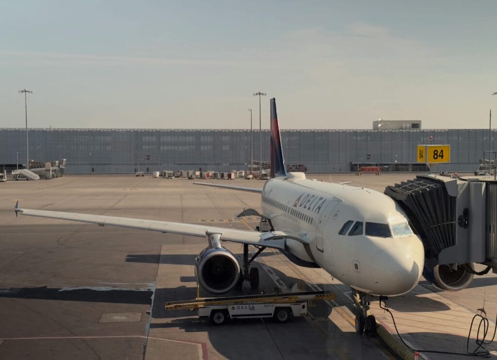 A Delta Airplane Docked At Montreal'S Airport Gate 84 During Daylight.