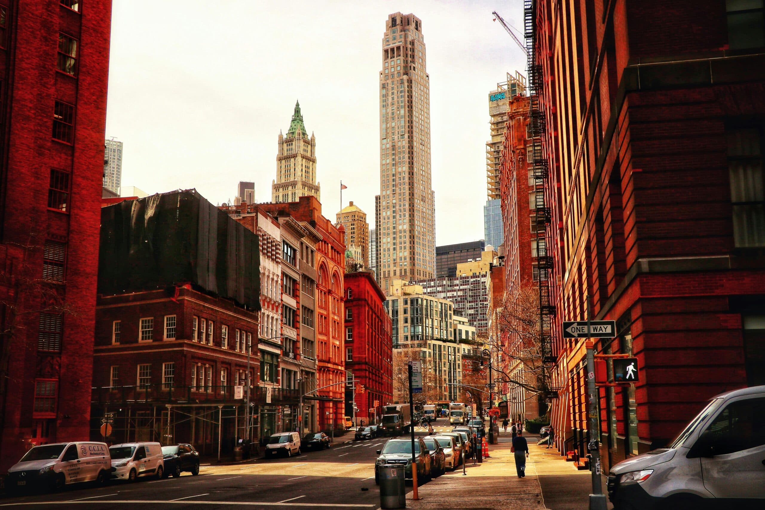 Dynamic Urban Street View Of Lower Manhattan With Iconic Skyscrapers And Historic Architecture.