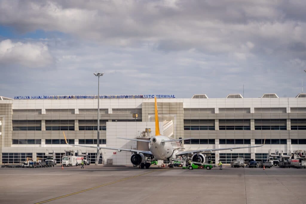 The Best Airport Black Car Service In New York City (2026): What Twenty Years On These Streets Taught Me 9 June 13, 2026 Airplane Parked At Antalya Airport With Terminal Building In The Backdrop Under Cloudy Skies.