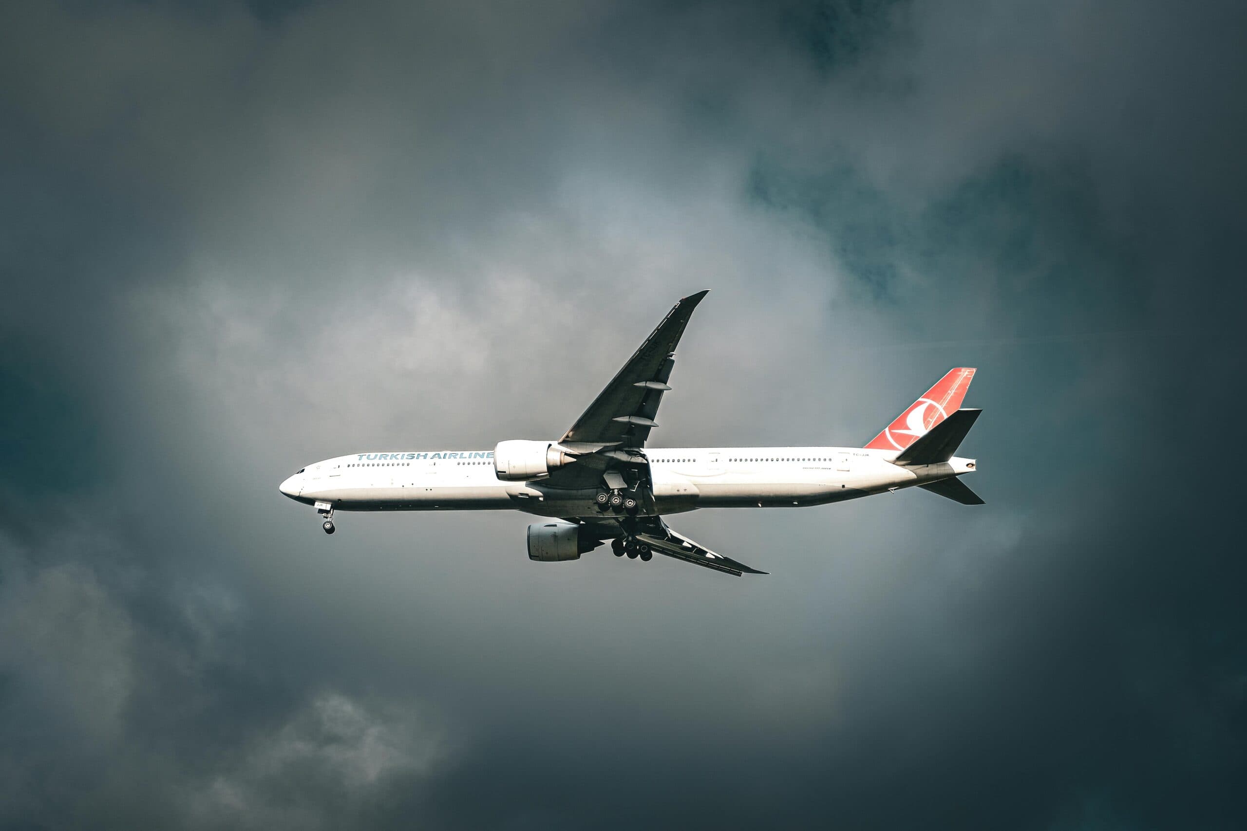 A Turkish Airlines Aircraft Flying Amidst Clouds Over Istanbul, Capturing Travel&Amp;Apos;S Essence.