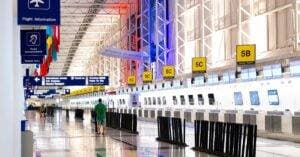 Wide View Of Chicago Airport Terminal Showcasing Architecture And Check-In Counters. Flags And Signages Add Vibrant Detail.
