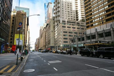 Urban Cityscape Of Midtown Manhattan With Skyscrapers, Vehicles, And Pedestrians.
