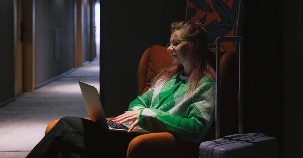 Woman Sitting In Corner Of Hotel Hallway Working On Laptop