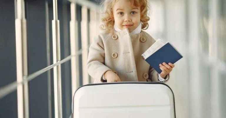 Cute Child With Passport And Suitcase In A Modern Airport Terminal.