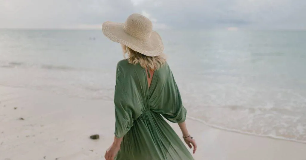Back View Of Unrecognizable Female Tourist Wearing Straw Hat And Summer Dress Standing On Seashore In Cloudy Day