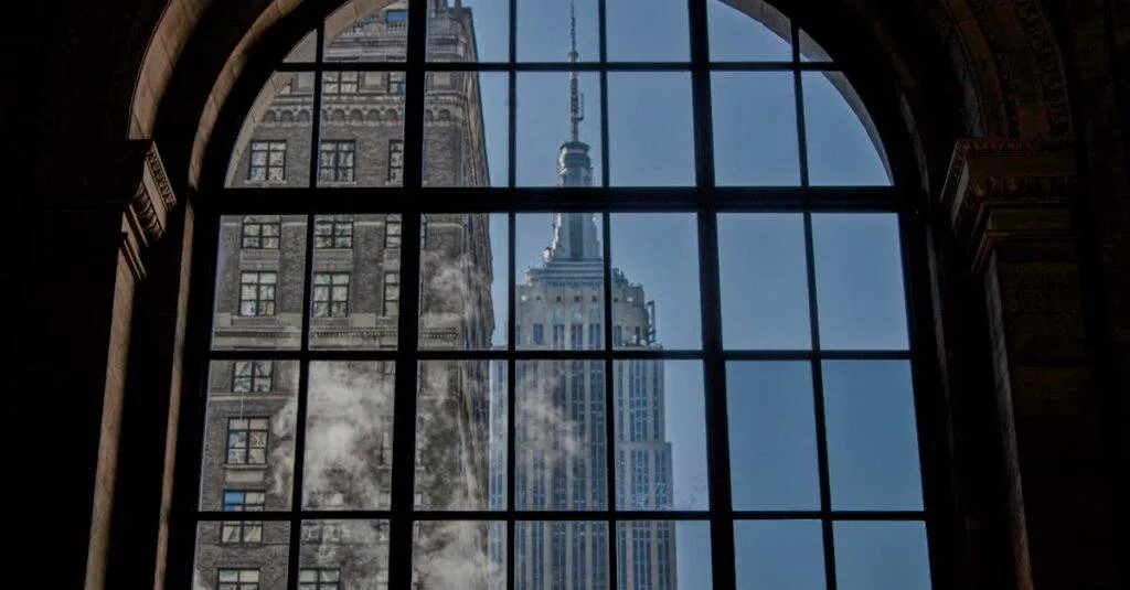 View Of The Empire State Building Framed By An Arched Window, Capturing Its Iconic New York City Architecture.