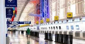 Wide View Of Chicago Airport Terminal Showcasing Architecture And Check-In Counters. Flags And Signages Add Vibrant Detail.