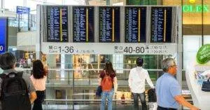 Passengers Checking The Departure Board At Hong Kong International Airport Terminal.