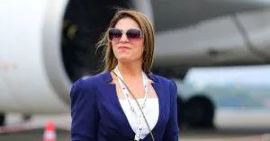 Stylish Businesswoman Standing Confidently In Front Of An Airplane At An Airport, Exuding Professionalism.