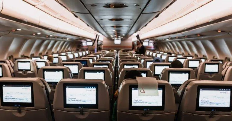 Comfortable Airplane Cabin Interior Featuring In-Flight Entertainment Screens On All Seats.