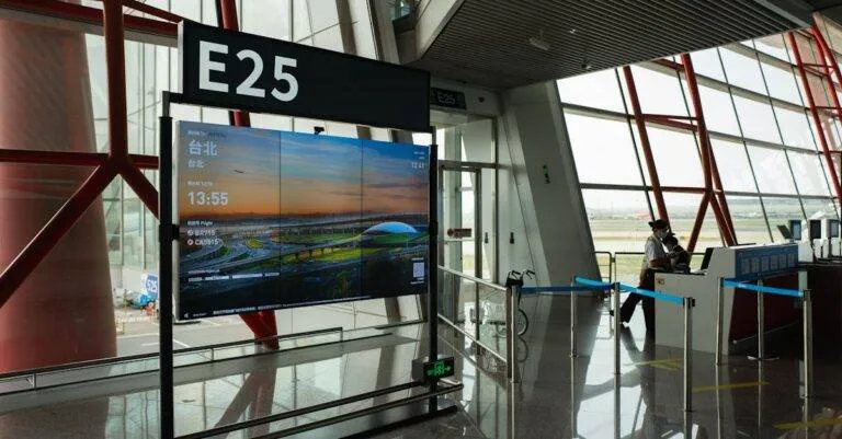 A View Of A Modern Airport Terminal Showcasing Gate E25 With A Flight Display Board.