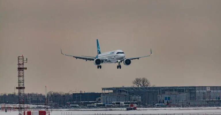 Powerful Airplane Flying Over Snowy Terrain And Preparing For Landing On Aerodrome Airfield Against Cloudy Sunset Sky