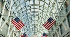 Interior Of Chicago O'Hare Airport With American Flags And Globe Sculpture.