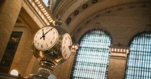 From Below Of Vintage Golden Clock Placed In Hallway With Aged Interior With Ornamental Walls And Windows And High Ceilings Placed In Grand Central Terminal In New Your City In Daytime