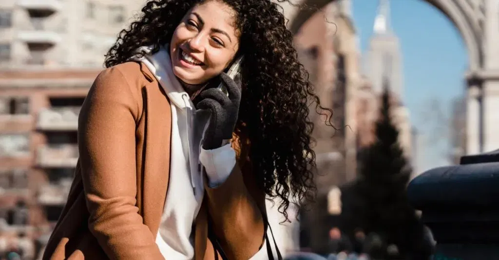Book Your Service With Jetblack: The Ultimate Guide To Luxury, Reliability, And Stress-Free Ground Transportation For Every Occasion 10 April 3, 2026 Young Woman With Curly Hair Happily Chatting On Phone In A City Setting, Enjoying A Sunny Day.