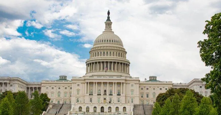 View Of United States Capitol With Neoclassical Architecture Against A Cloudy Sky In Washington D.c.