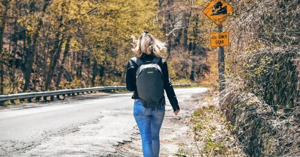 Car Pickup Near Me: Discovering Convenience With Car Pickup Near Me 3 April 4, 2026 A Woman With A Backpack Walks Along A Scenic Forest Road In Spring, Enjoying An Outdoor Hike.