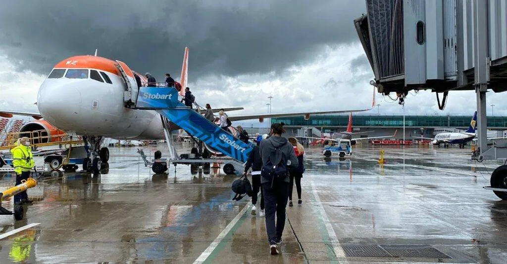 Passengers Boarding An Aircraft At Edinburgh Airport On A Rainy Day, Highlighting Travel Dynamics.