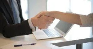 Close-Up Of A Professional Handshake Over A Laptop During A Business Meeting In An Office.