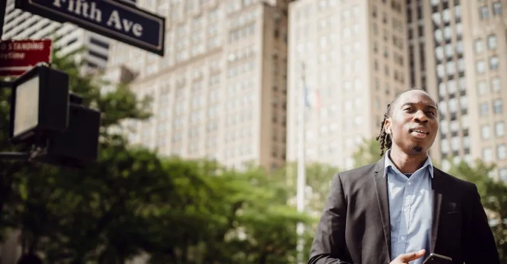 A Young Man Stands On Fifth Avenue In New York City Holding A Smartphone, Showcasing Urban Lifestyle.