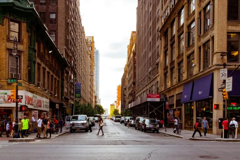 Lively Urban Street In New York City With Pedestrians And Vehicles On A Sunny Day.