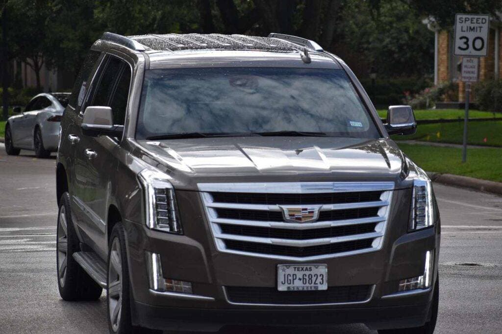cadillac-escalade-suv-car-5264974-1.jpg A bustling LaGuardia Airport arrivals area with travelers and signage, framed by a modern terminal, ready for an affordable car service from LaGuardia to NYC.