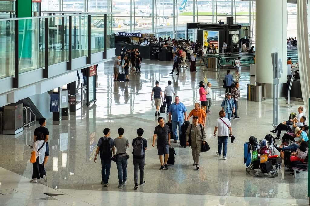 Lga Airport Cab: 7 Honest Facts First-Time Visitors Need In 2026 2 August 17, 2026 Passengers Walking And Seated In A Bustling Hong Kong Airport Terminal.